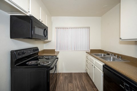 a kitchen with a stove and a sink and a microwave